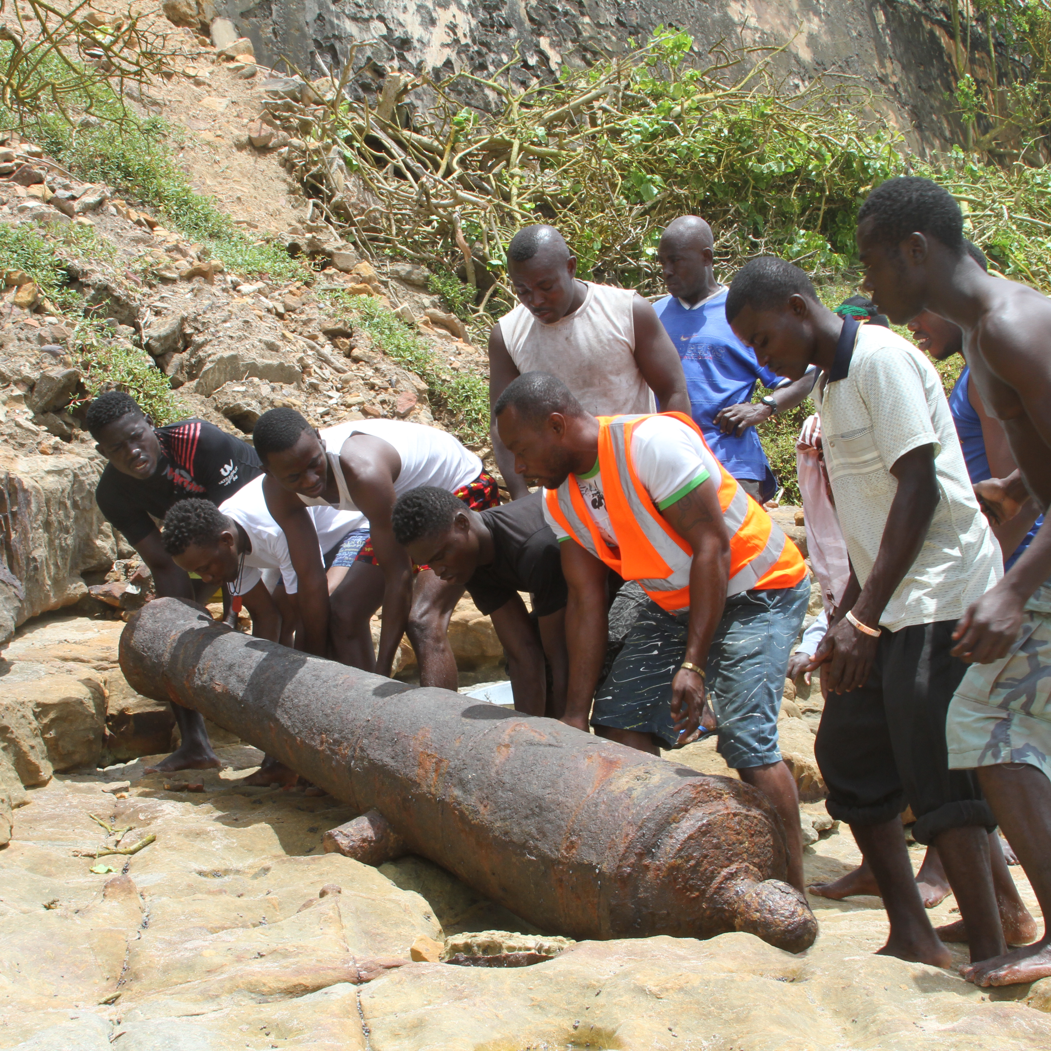Several people unearth a rusted canon